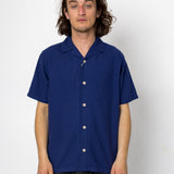 Man wearing a blue short-sleeve shirt against a white background