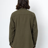 Person wearing an olive green shirt against a white background