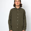 Man wearing an olive green button-up shirt against a white background