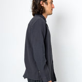 Man wearing a dark gray shirt and pants against a white background