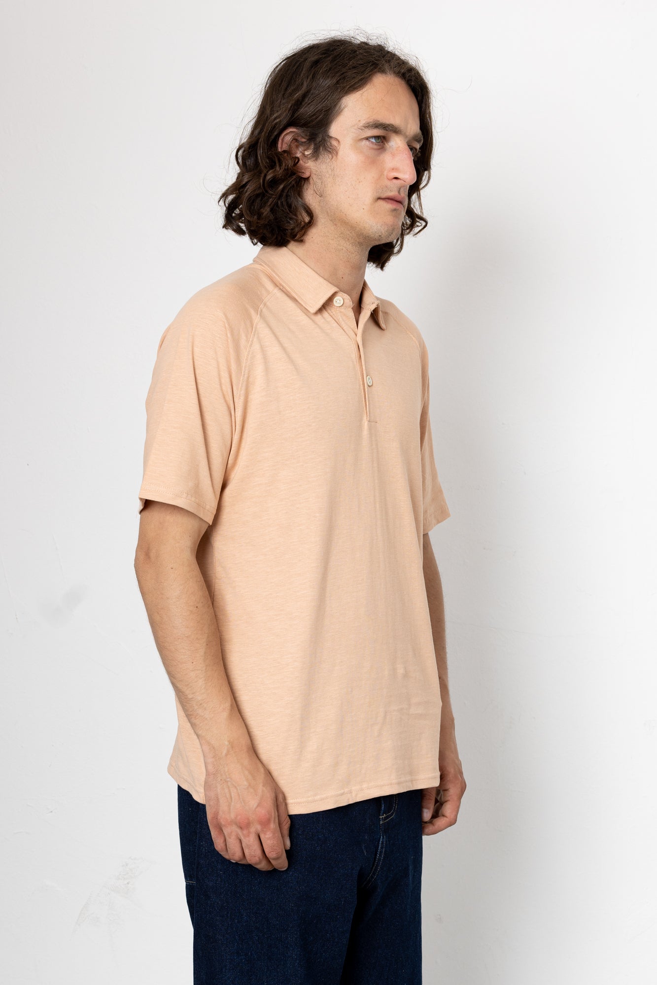 Man wearing a beige polo shirt against a white background