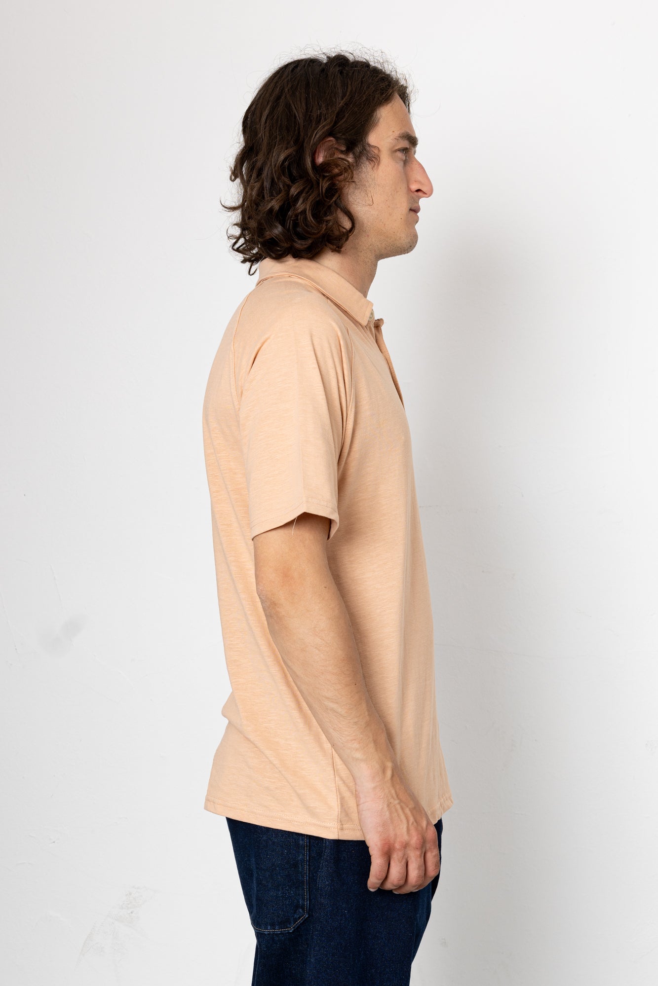 Man wearing a beige polo shirt against a white background