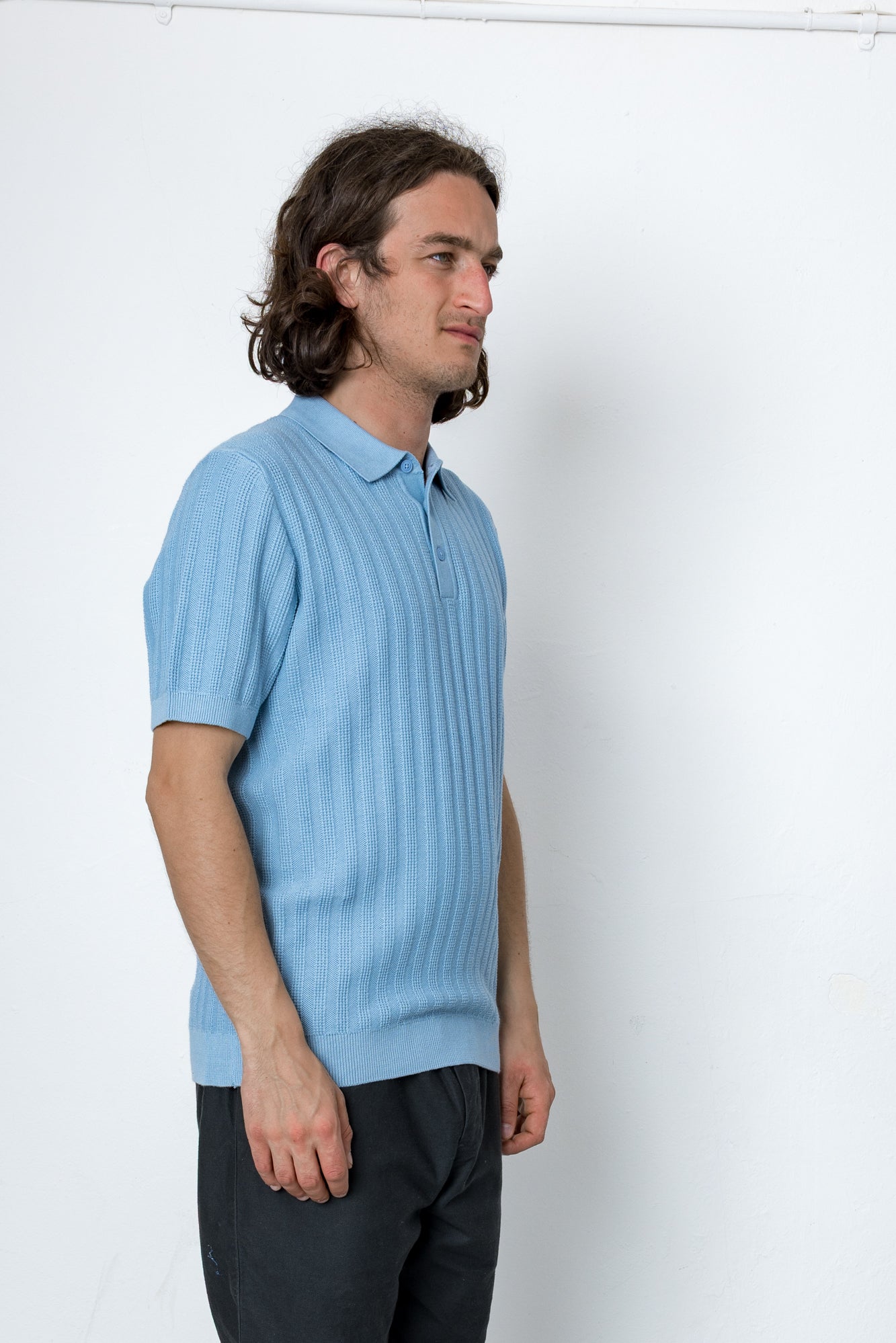 Man wearing blue polo shirt against white background