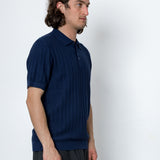 Man wearing a blue polo shirt against a white background