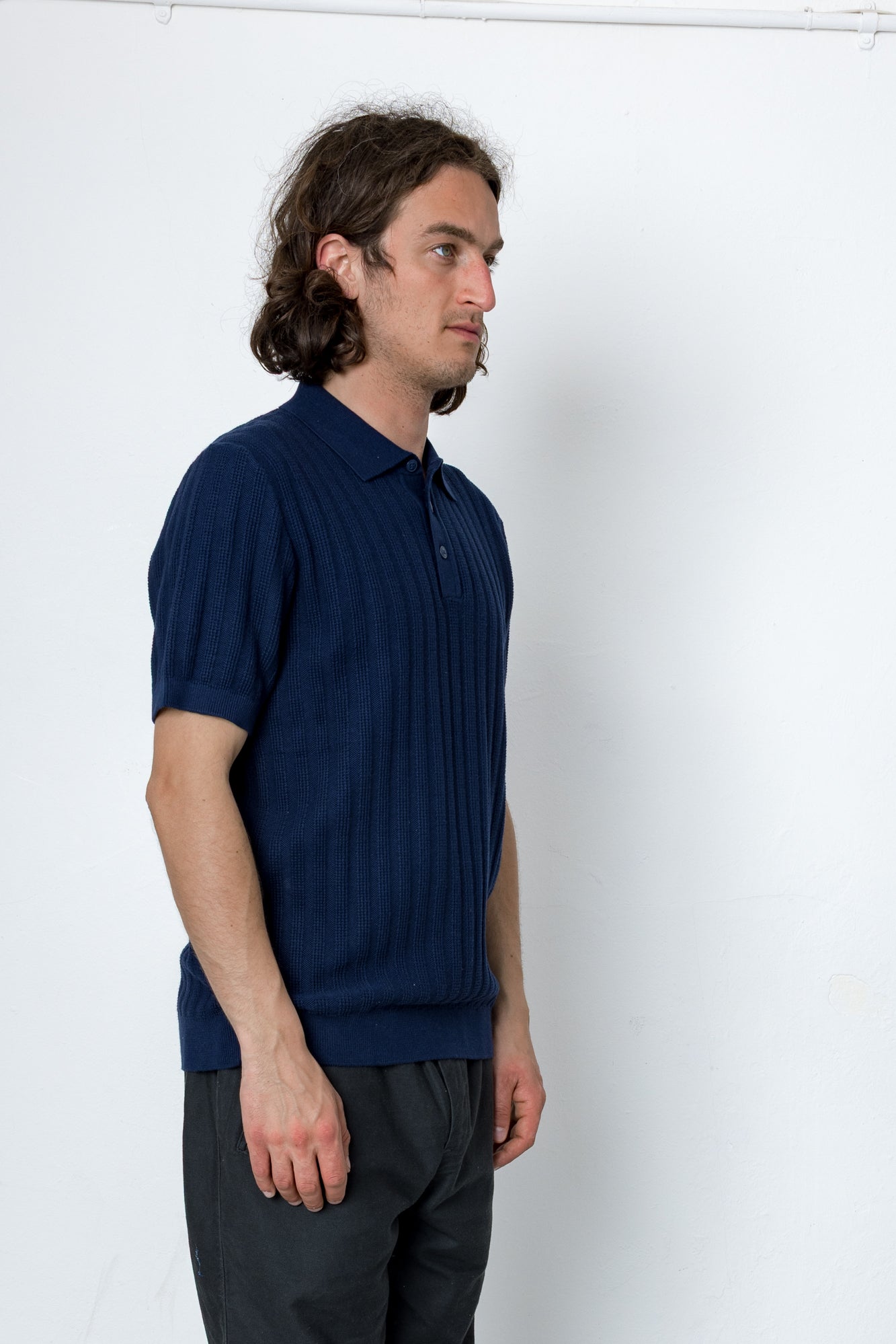 Man wearing a blue polo shirt against a white background