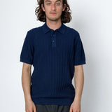 Man wearing a navy blue polo shirt against a white background
