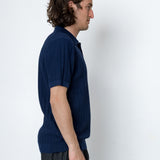 Man wearing a dark blue shirt against a white background