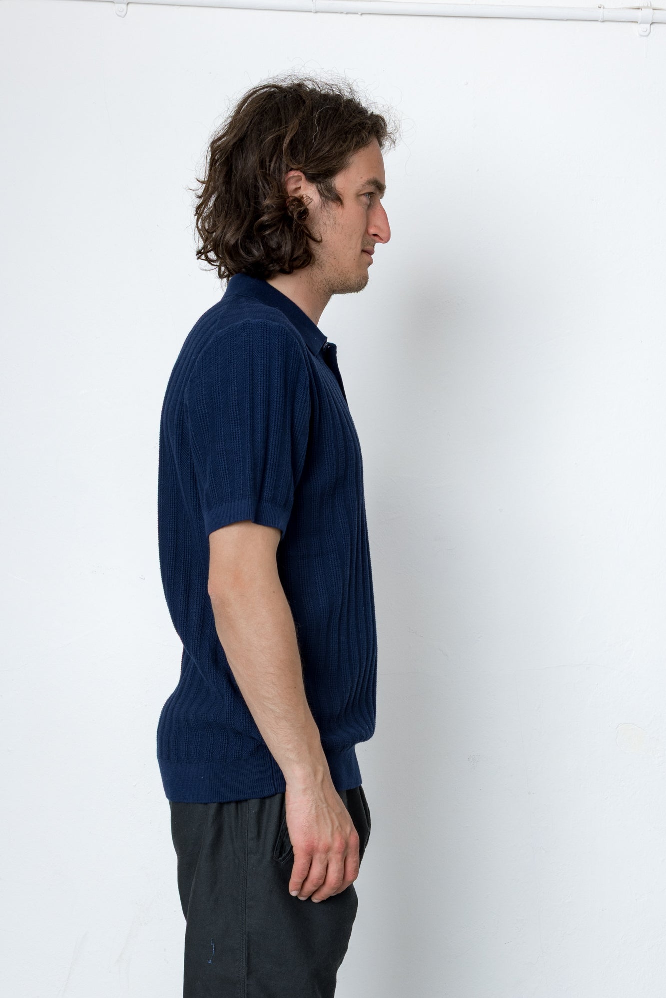 Man wearing a dark blue shirt against a white background