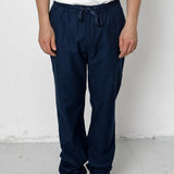 Person wearing navy pants and black shoes on a white background