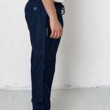 Person wearing navy pants and black shoes on a white background