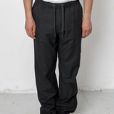 Person wearing black pants and a white shirt against a white background