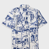 A short-sleeve button-up shirt with a white base and a navy blue sketch-style architectural pattern, displayed flat against a light gray background.