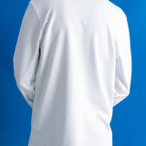 A person shown from the back wearing a plain white long-sleeve t-shirt and dark navy pants, standing against a solid blue background.