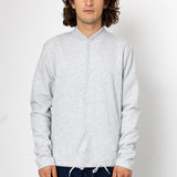Man wearing a light gray long-sleeve shirt against a white background