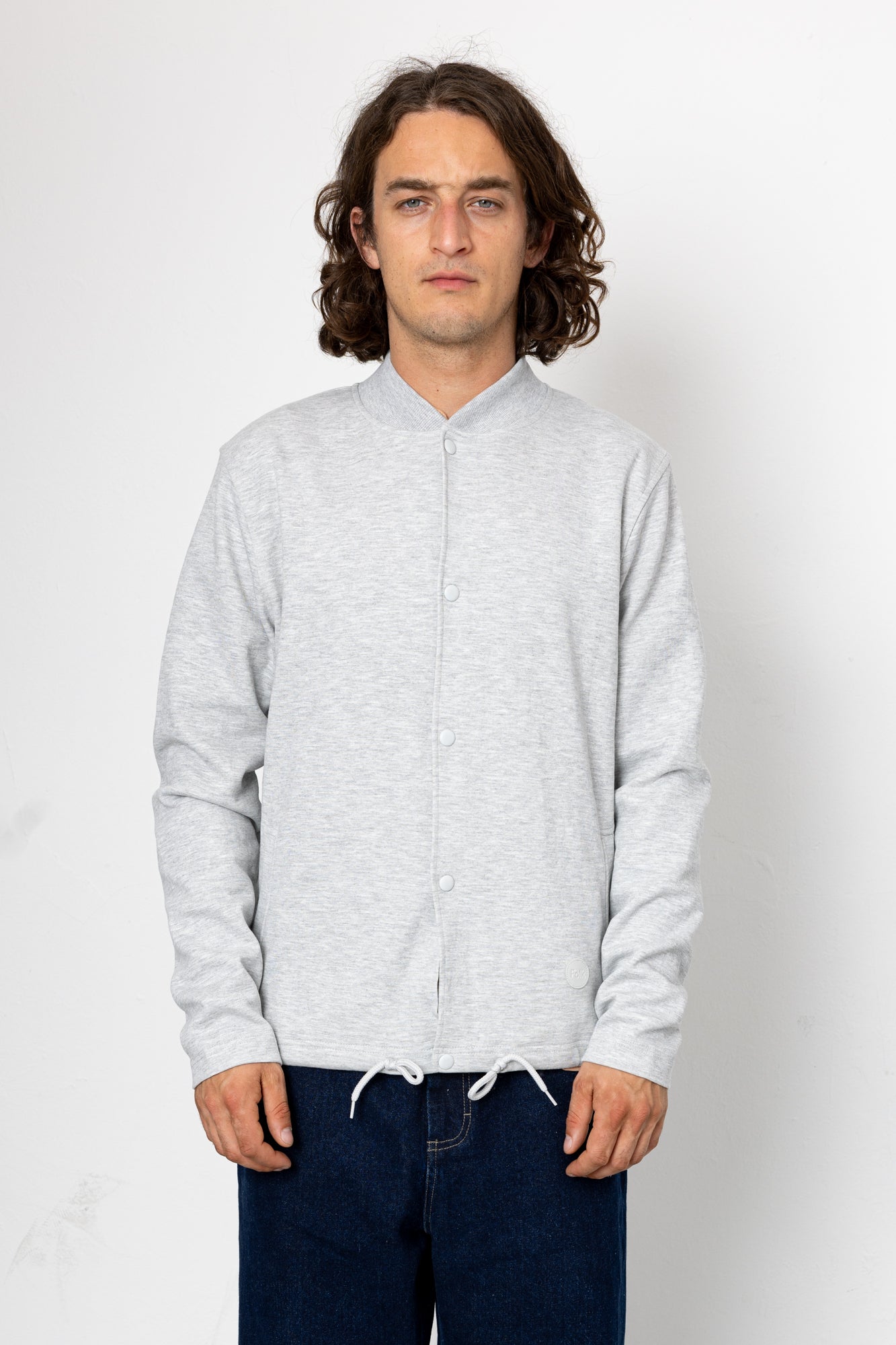 Man wearing a light gray long-sleeve shirt against a white background
