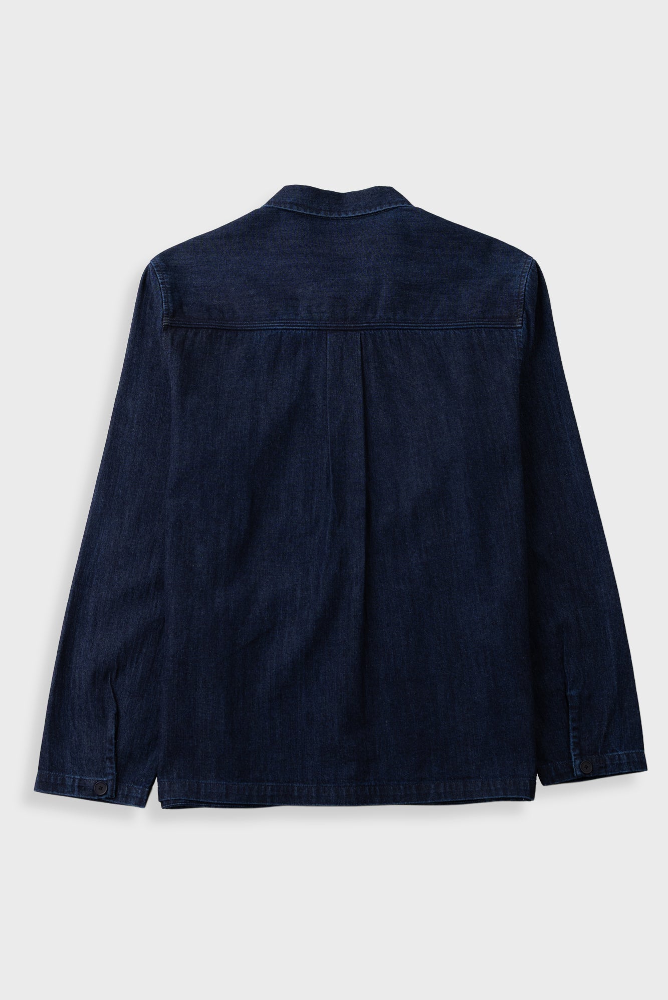 A dark navy blue denim shirt jacket shown from the back, featuring a classic collar and long sleeves, laid flat against a light gray background.