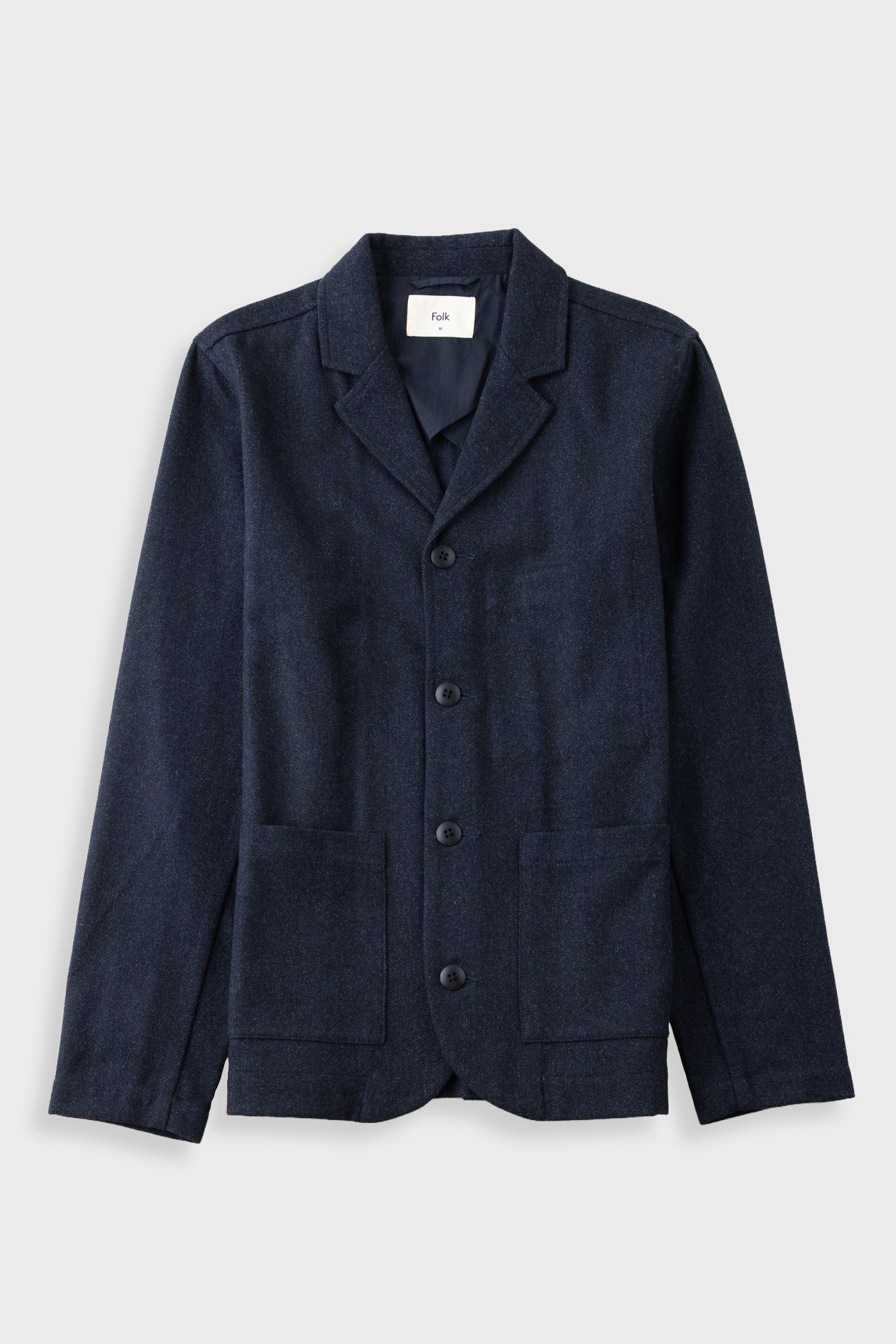 A dark navy blue textured jacket with notch lapels, a three-button front closure, and two front patch pockets, displayed flat against a light gray background.