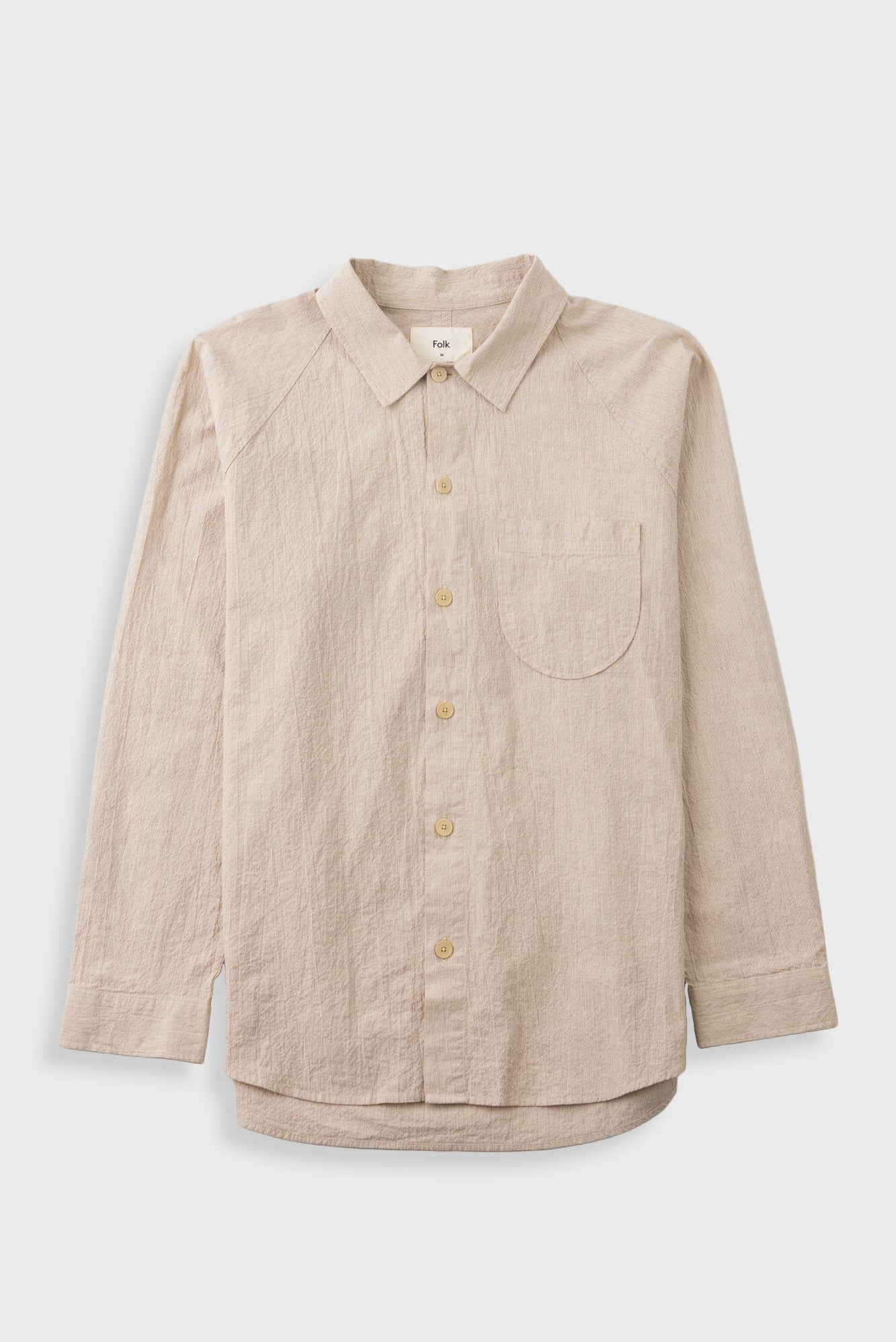 A light beige linen button-up shirt with a chest pocket, displayed flat against a light gray background.