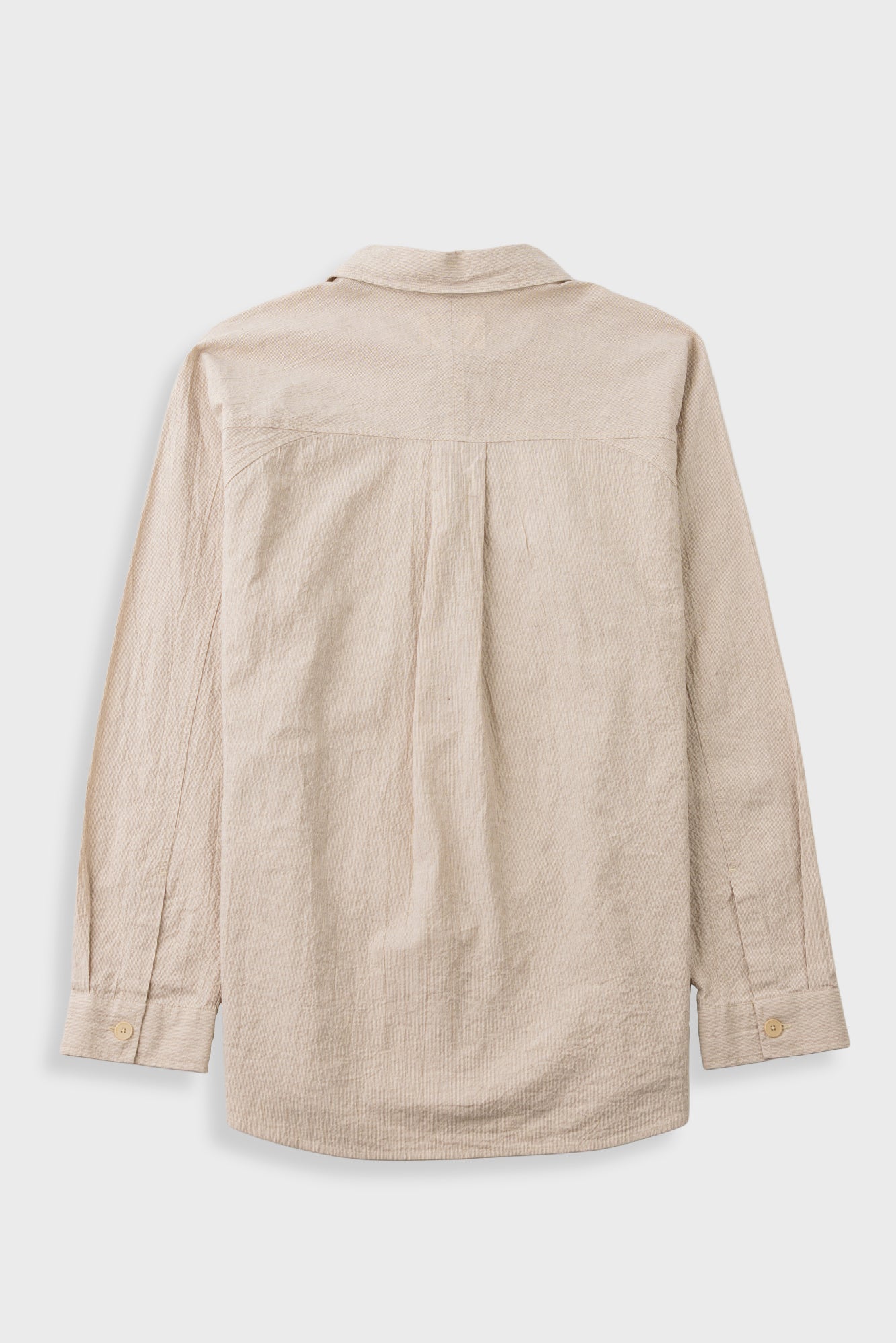 A light beige linen shirt shown from the back, featuring a button-down collar, long sleeves, and a relaxed fit, photographed against a neutral light gray background.