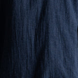 A close-up of dark navy blue textured fabric with a crinkled linen-like weave.