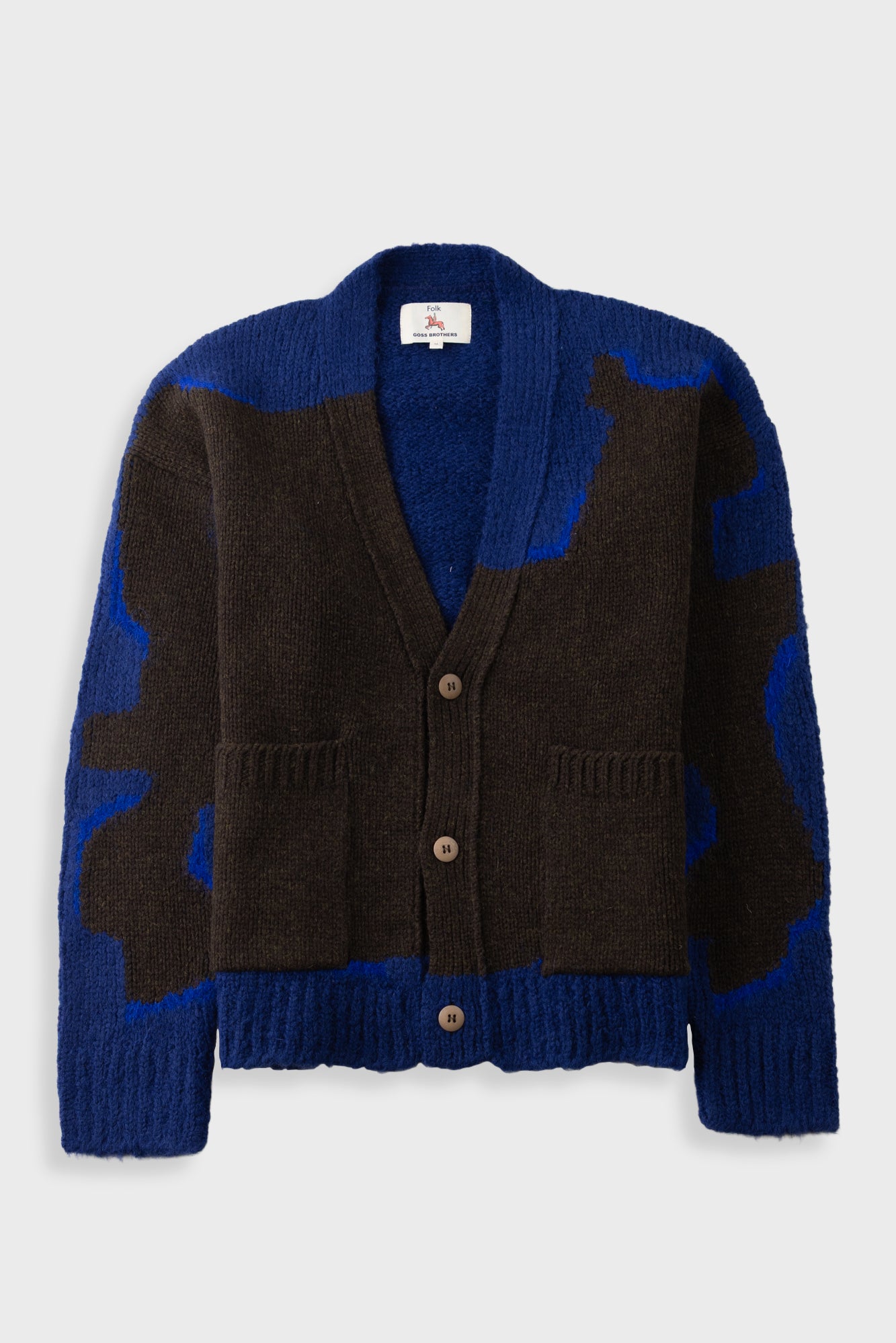 A knit cardigan sweater with a color-blocked pattern of dark brown and royal blue, featuring a V-neck, three brown buttons, and front patch pockets, shown against a light gray background.