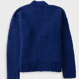 A dark blue ribbed knit sweater shown from the back, featuring a crew neck and long sleeves, photographed against a light gray background.