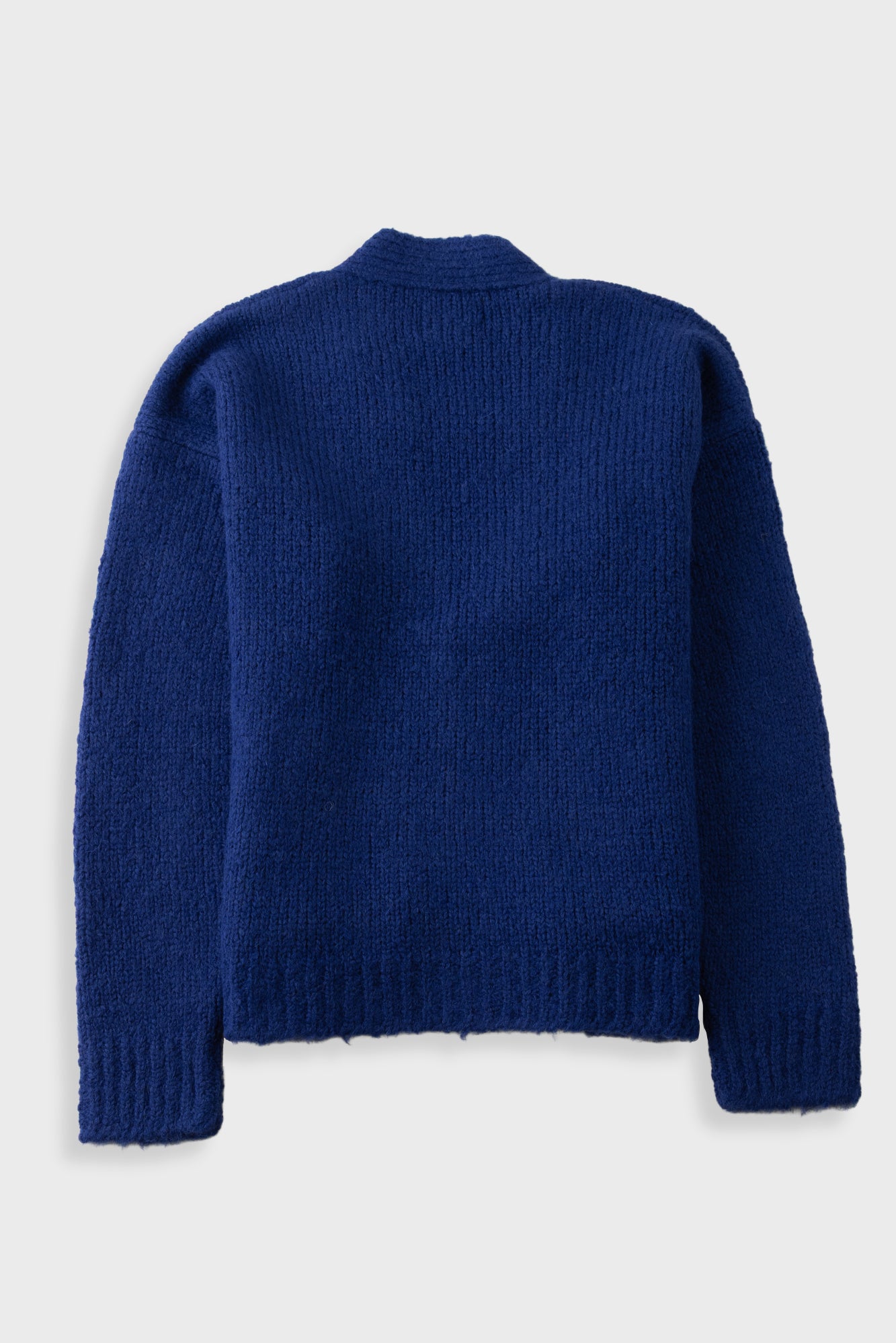 A dark blue ribbed knit sweater shown from the back, featuring a crew neck and long sleeves, photographed against a light gray background.