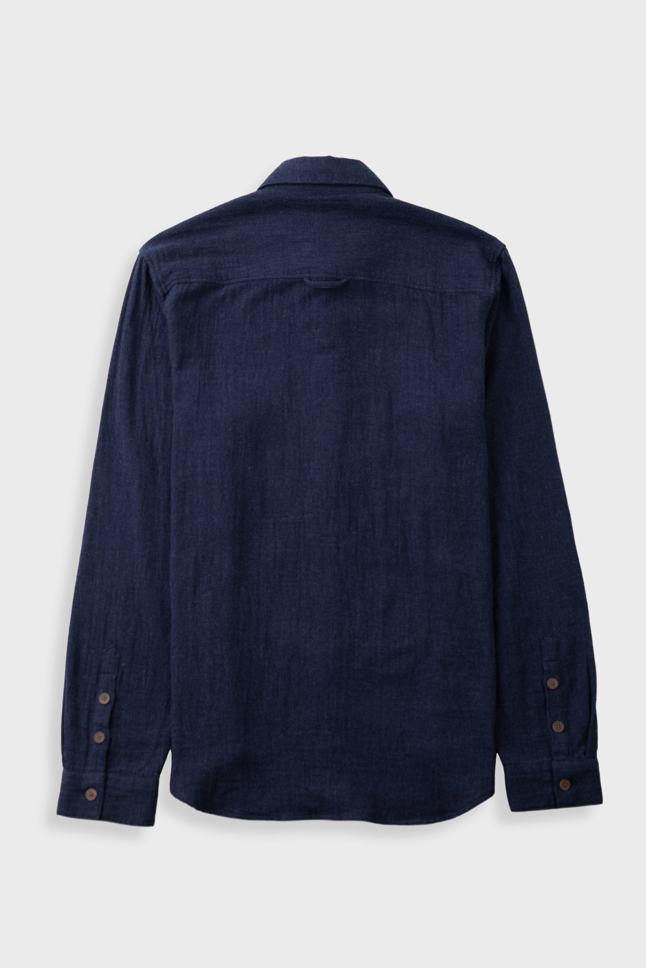 Dark navy button up shirt laid against a grey backdrop