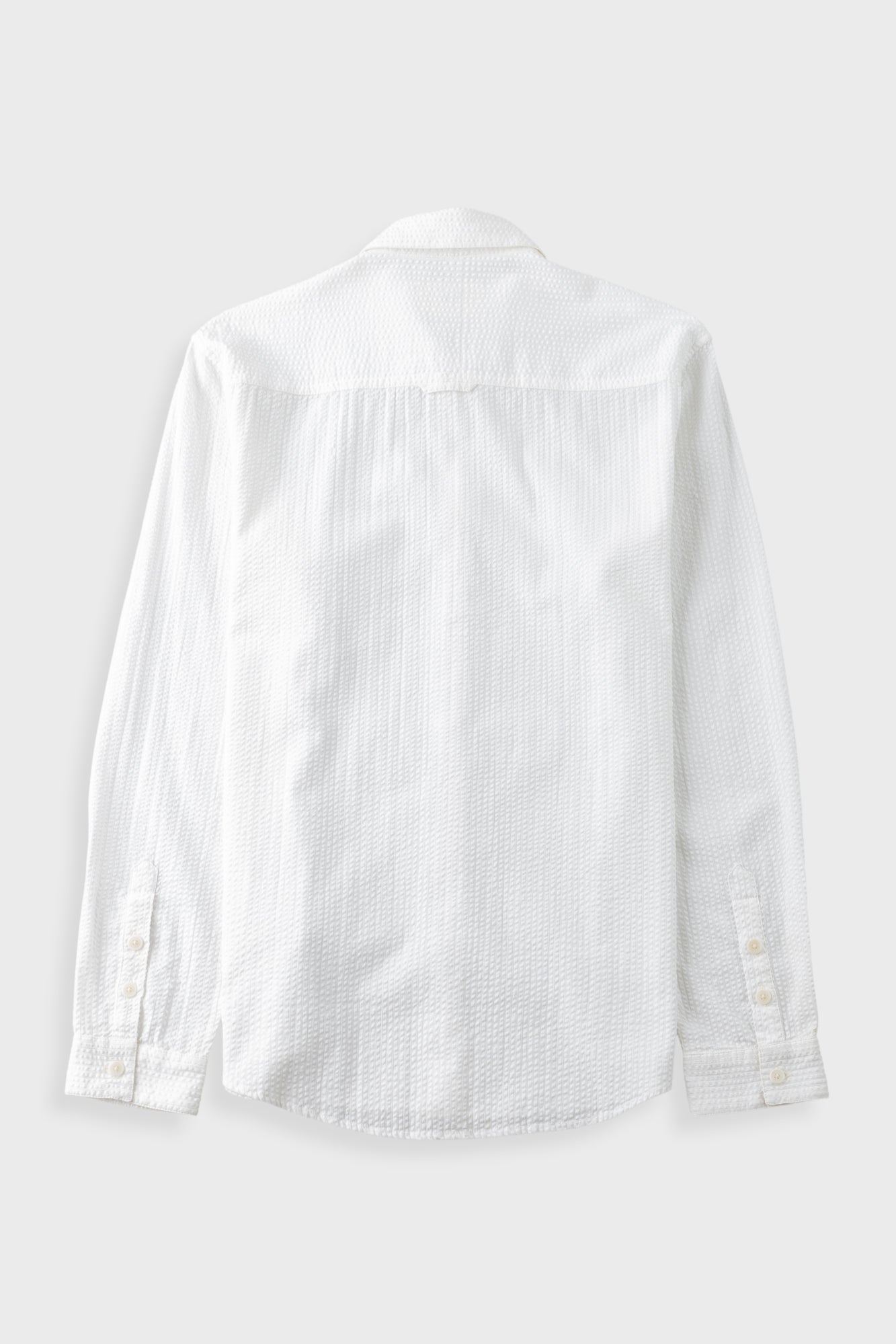 White textured shirt against a pale grey background