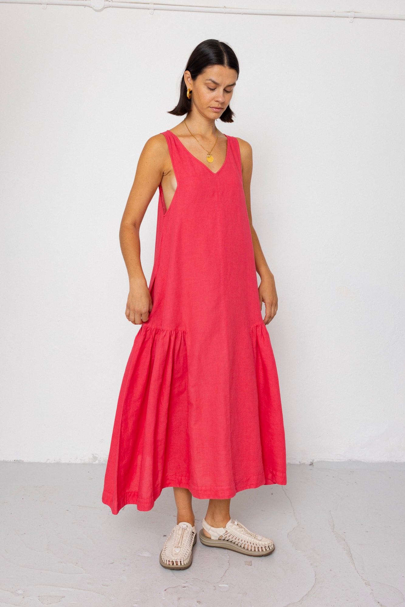 Woman wearing a red sleeveless dress against a white background