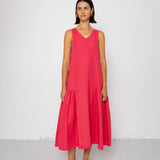 Woman wearing a pink dress standing against a white background