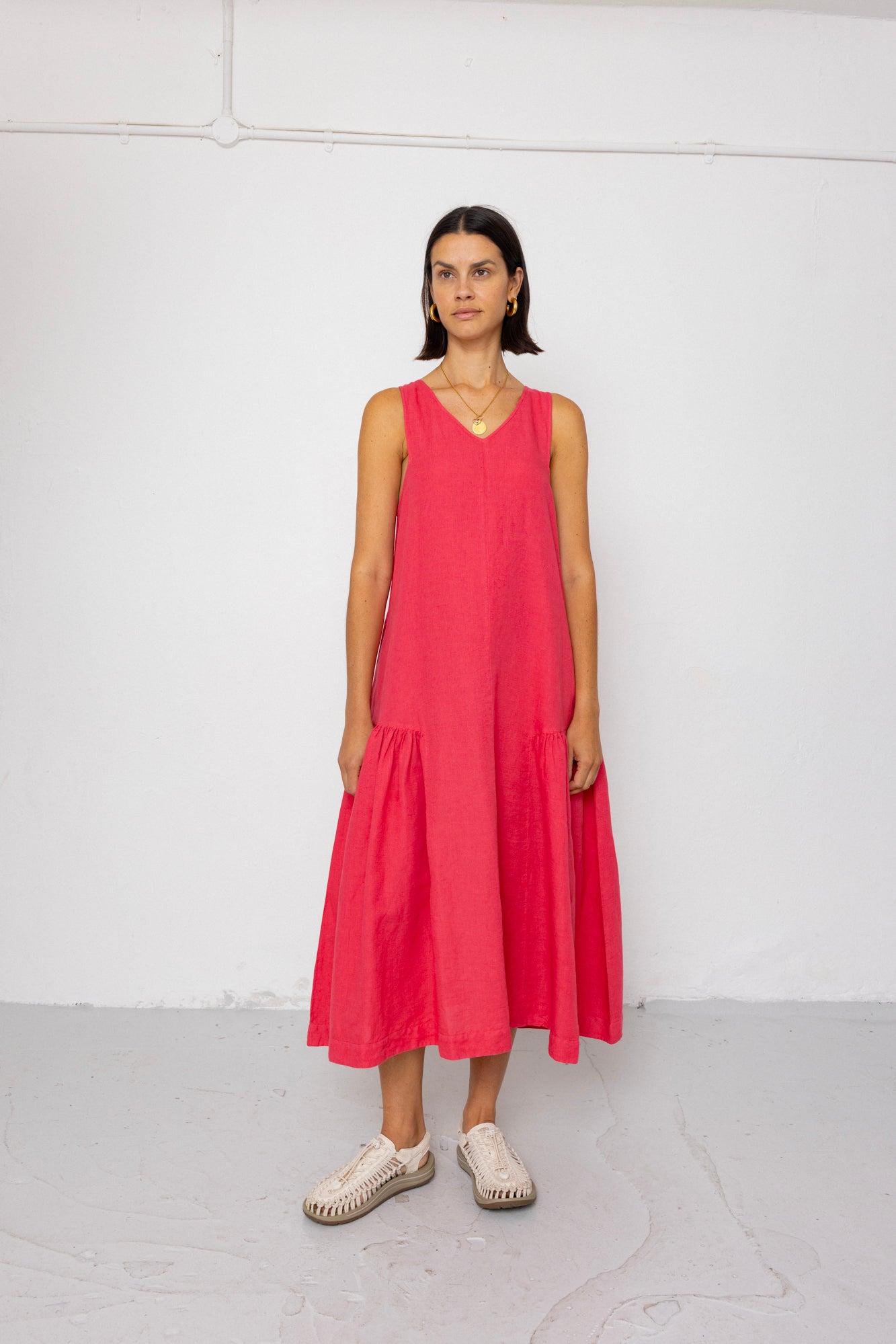 Woman wearing a pink dress standing against a white background