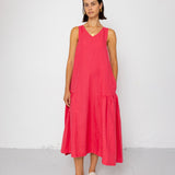 Woman wearing a pink sleeveless dress against a white background