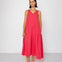 Woman wearing a pink sleeveless dress against a white background
