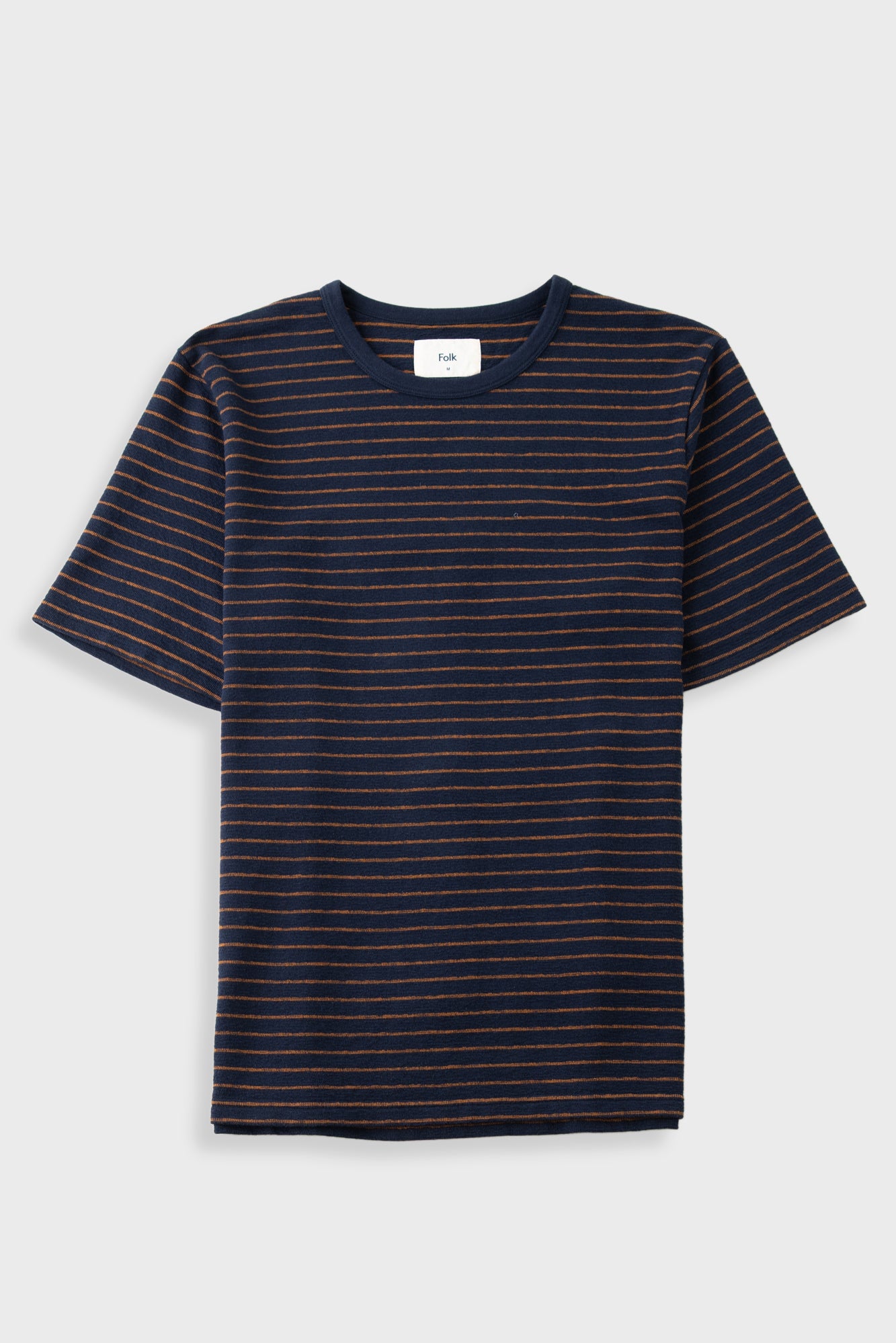 A short-sleeve crewneck t-shirt with thin horizontal navy blue and orange stripes, displayed flat against a light gray background.