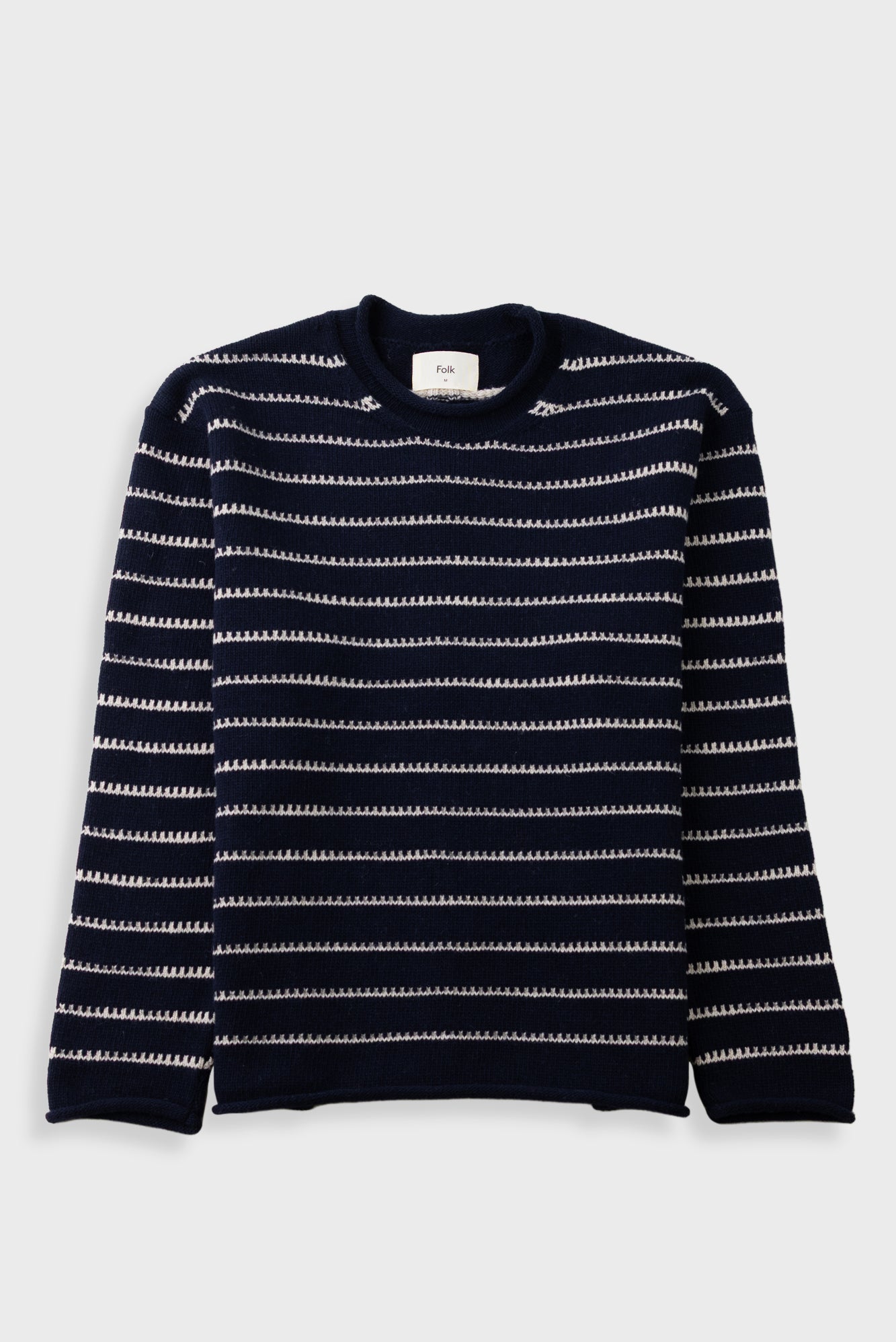 A navy blue crewneck sweater with horizontal white knit stripes, laid flat against a light gray background.