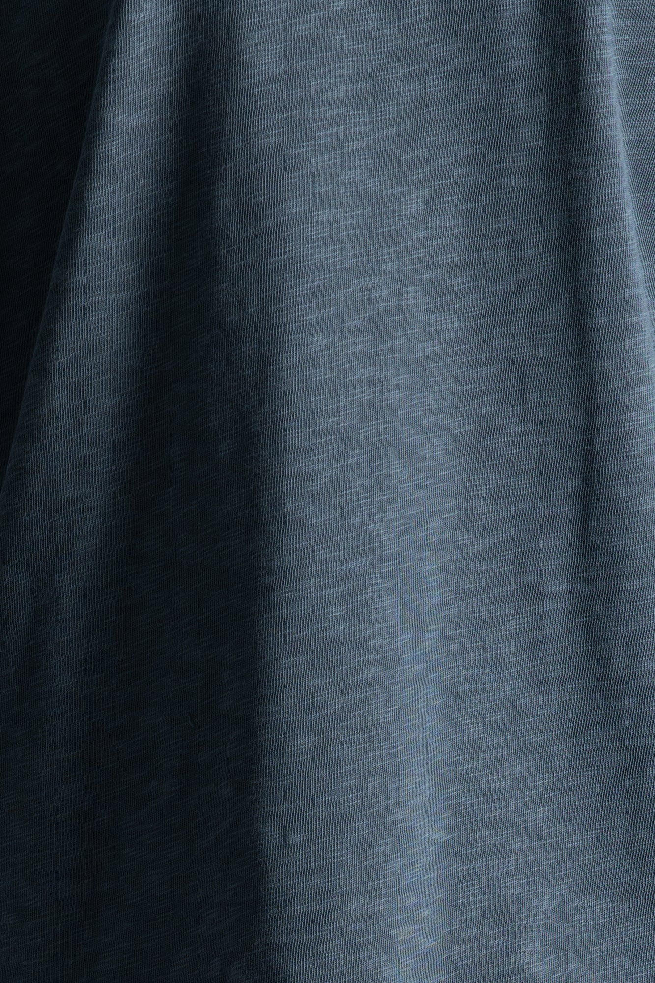 A close-up of dark heather gray fabric with soft folds and a slightly textured surface.