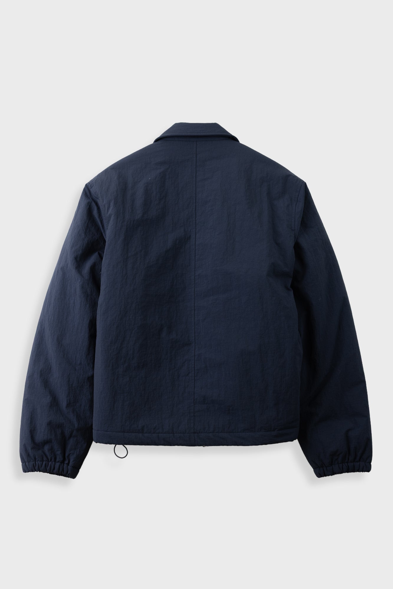 A dark navy blue jacket shown from the back, featuring a classic collar, long sleeves, and elasticized cuffs, photographed against a light gray background.