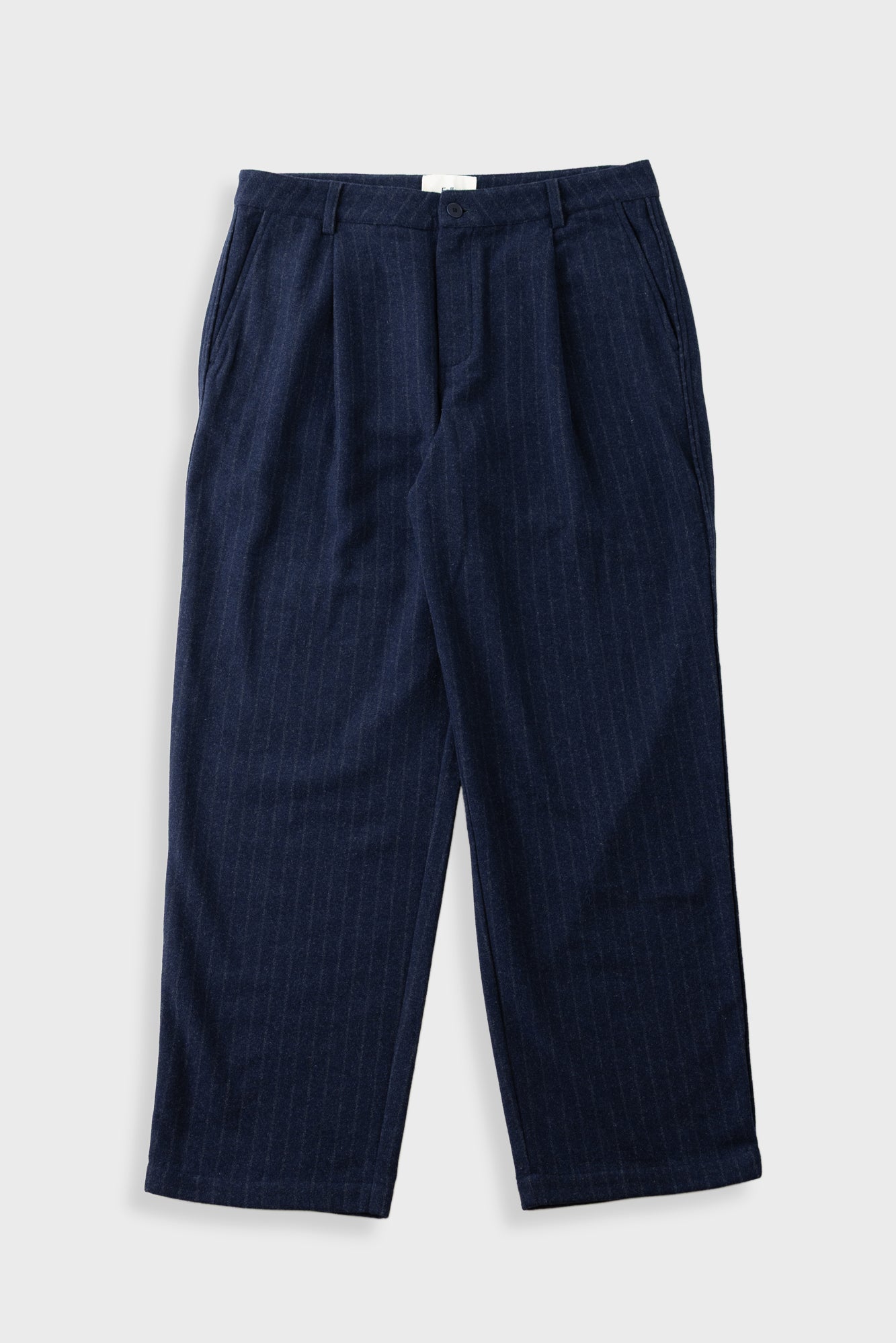 A pair of dark navy blue pinstriped trousers laid flat against a light gray background.